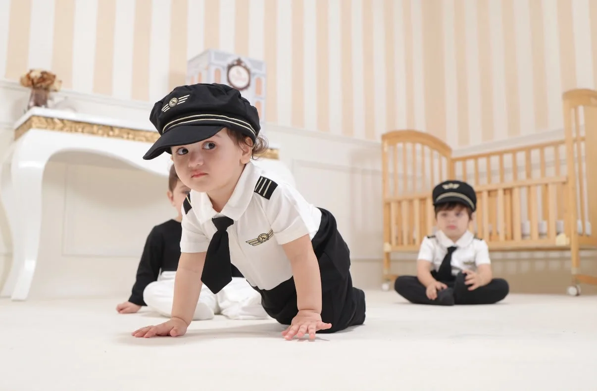 Young children in playful pilot-inspired Pythal outfits in a bright nursery setting.